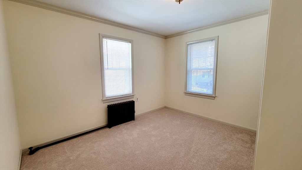 149 Powder House Boulevard, Unit 149 Somerville, MA 02144 - Photo 6 of 11 an empty room with windows