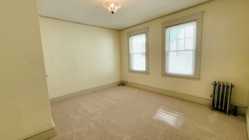 149 Powder House Boulevard, Unit 149 Somerville, MA 02144 - Photo 7 of 11 an empty room with windows