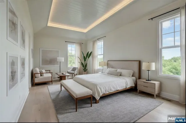 a bedroom with a bed couch and a large window