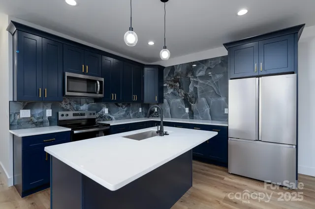 a kitchen with stainless steel appliances a refrigerator sink and microwave