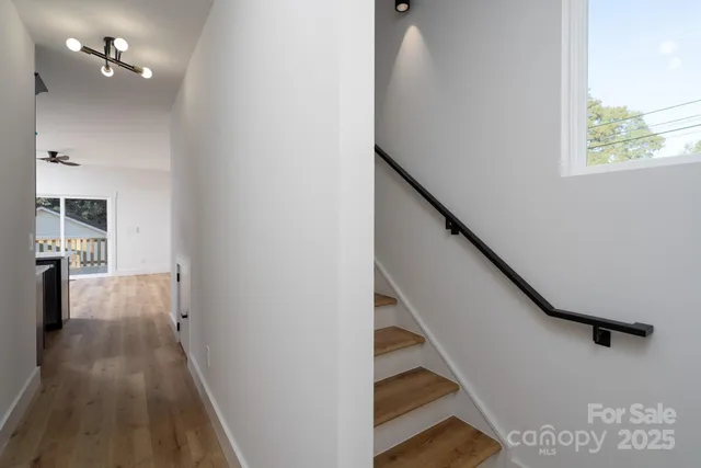 a view of a hallway with wooden floor and staircase