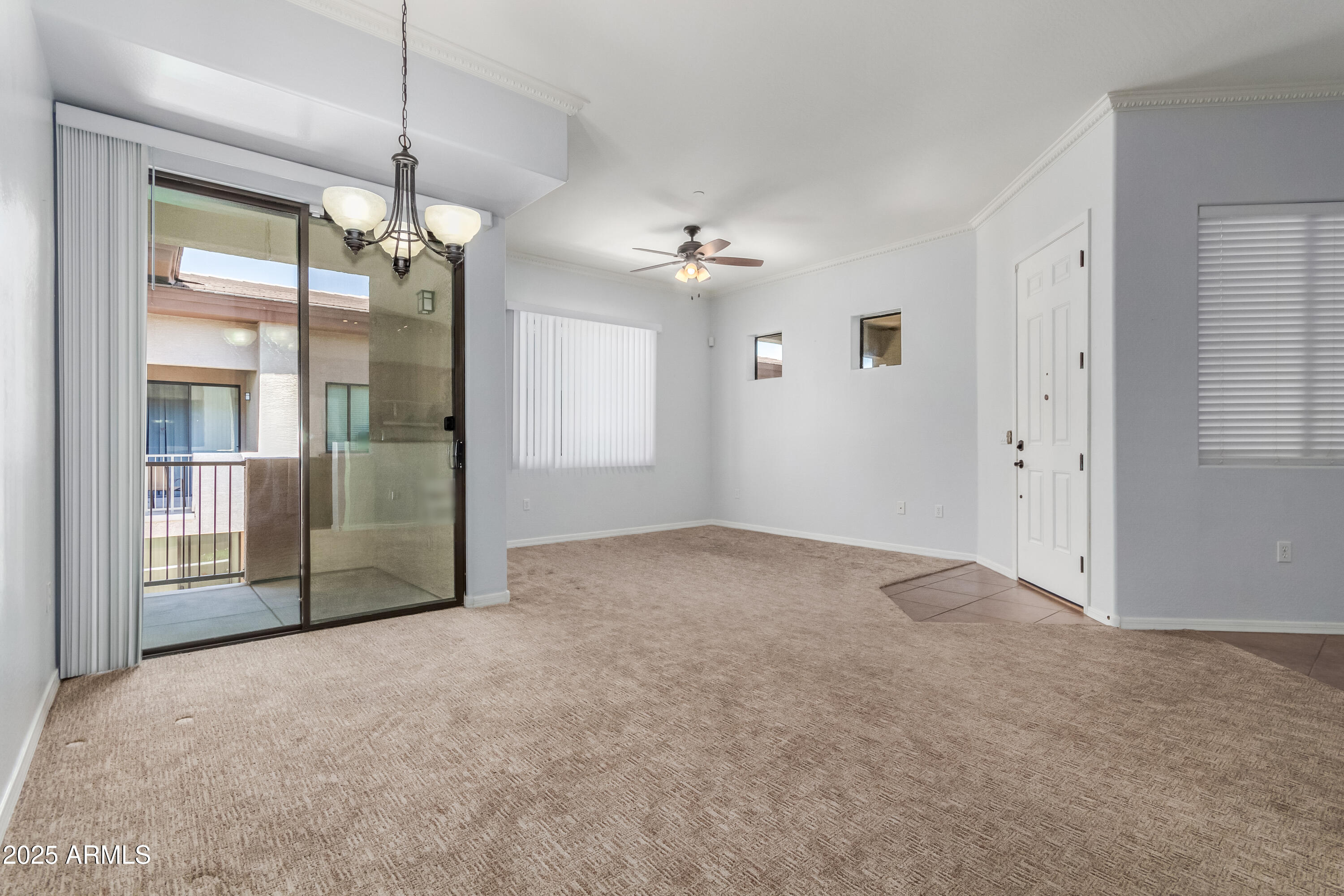 3330 South Gilbert Road, Unit 2018 Chandler, AZ 85286 - Photo 4 of 24 an empty room with chandelier fan and windows