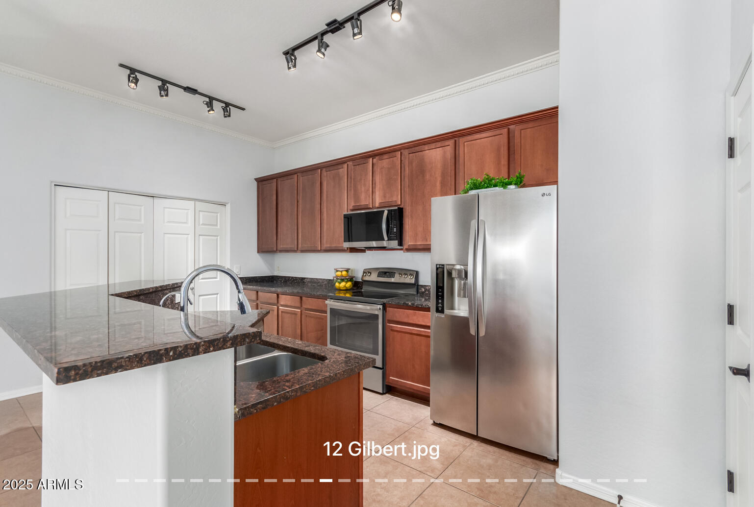 3330 South Gilbert Road, Unit 2018 Chandler, AZ 85286 - Photo 7 of 24 a kitchen with granite countertop stainless steel appliances a refrigerator stove top oven and sink