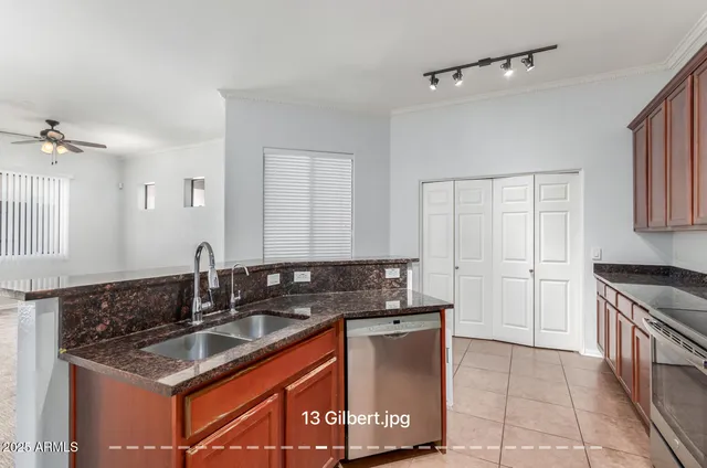 a kitchen with granite countertop a sink a stove and cabinets