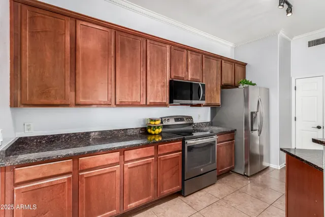 a kitchen with stainless steel appliances granite countertop a stove a sink dishwasher and a refrigerator
