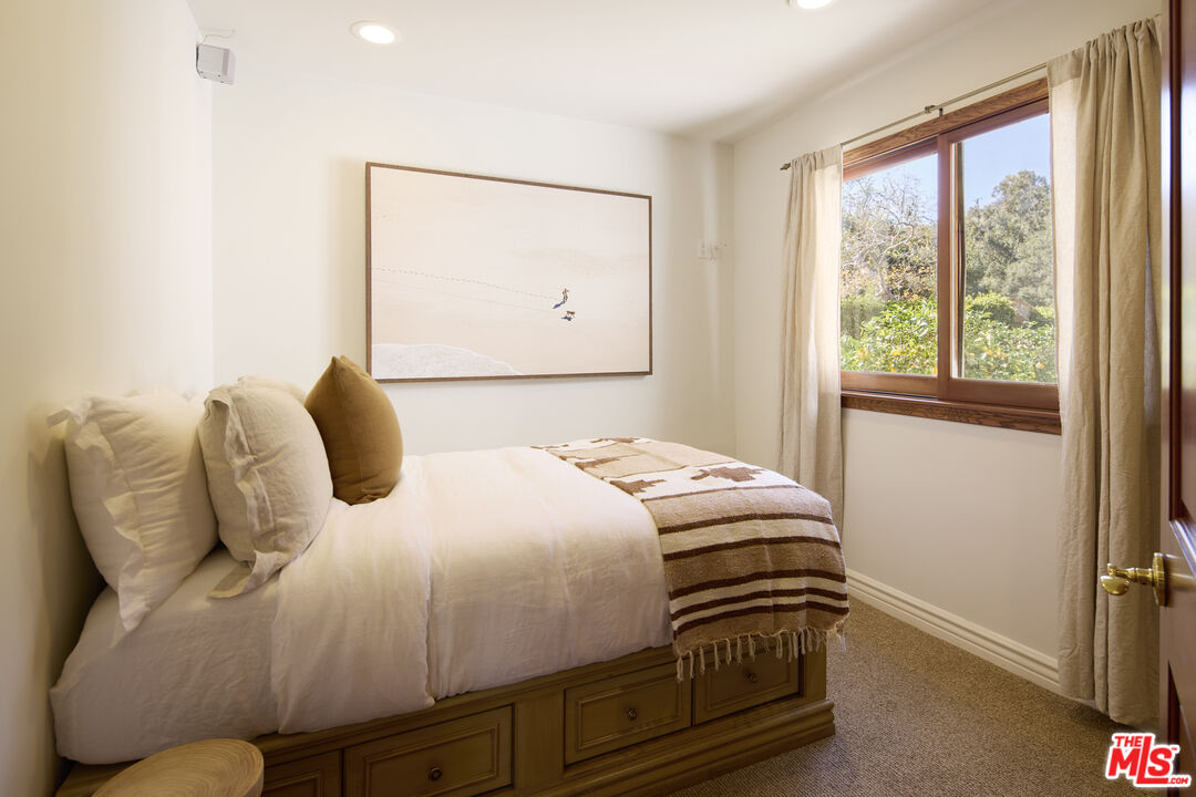 6138 Ramirez Canyon Road Malibu, CA 90265 - Photo 17 of 31 a bedroom with a bed and wooden floor