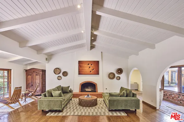 a living room with furniture a fireplace and large window