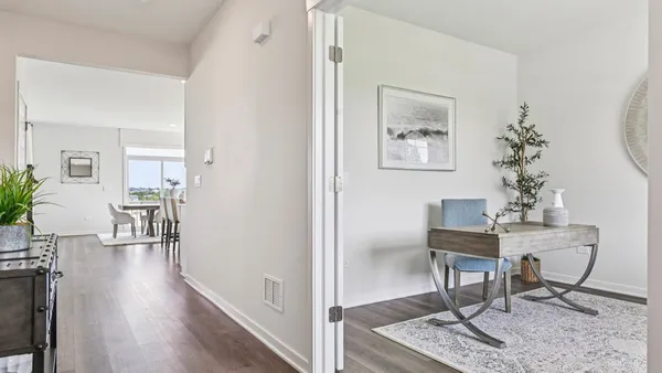 a view of a hallway with furniture and wooden floor