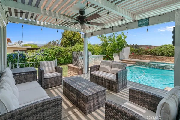a view of a swimming pool with lawn chairs under an umbrella