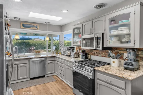 a kitchen with stainless steel appliances granite countertop a stove and a sink