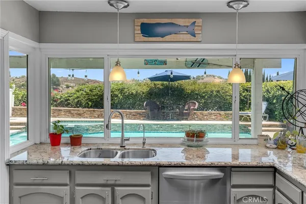 a kitchen with a granite countertop sink and a large window