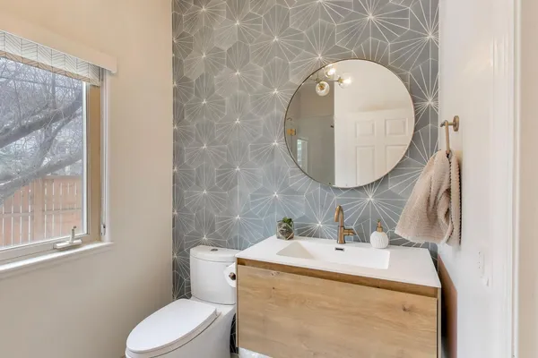 a bathroom with a sink mirror and toilet