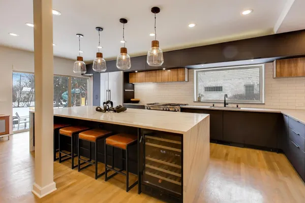a kitchen with stainless steel appliances granite countertop a sink a stove and a wooden floors