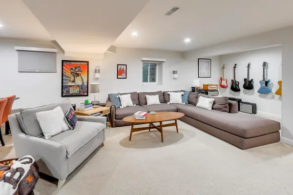 a living room with furniture a rug and a window