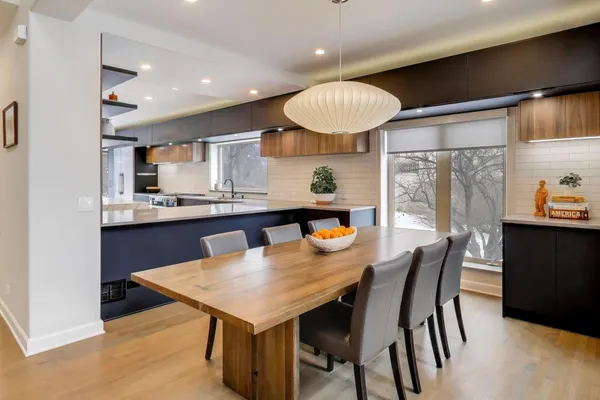 a kitchen with a dining table chairs and refrigerator
