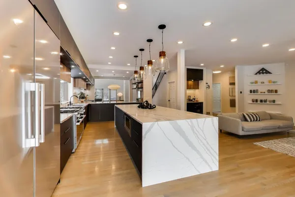 a large kitchen with stainless steel appliances kitchen island a stove a refrigerator a oven and a sink