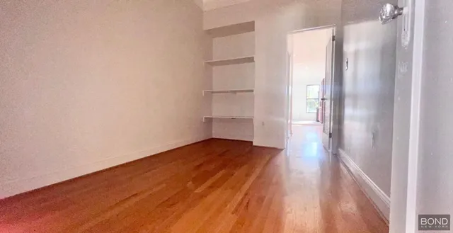 a view of empty room with wooden floor and cabinet