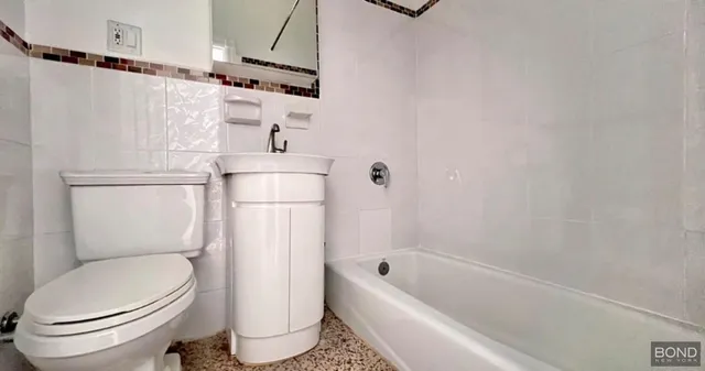 a bathroom with a toilet and a bath tub