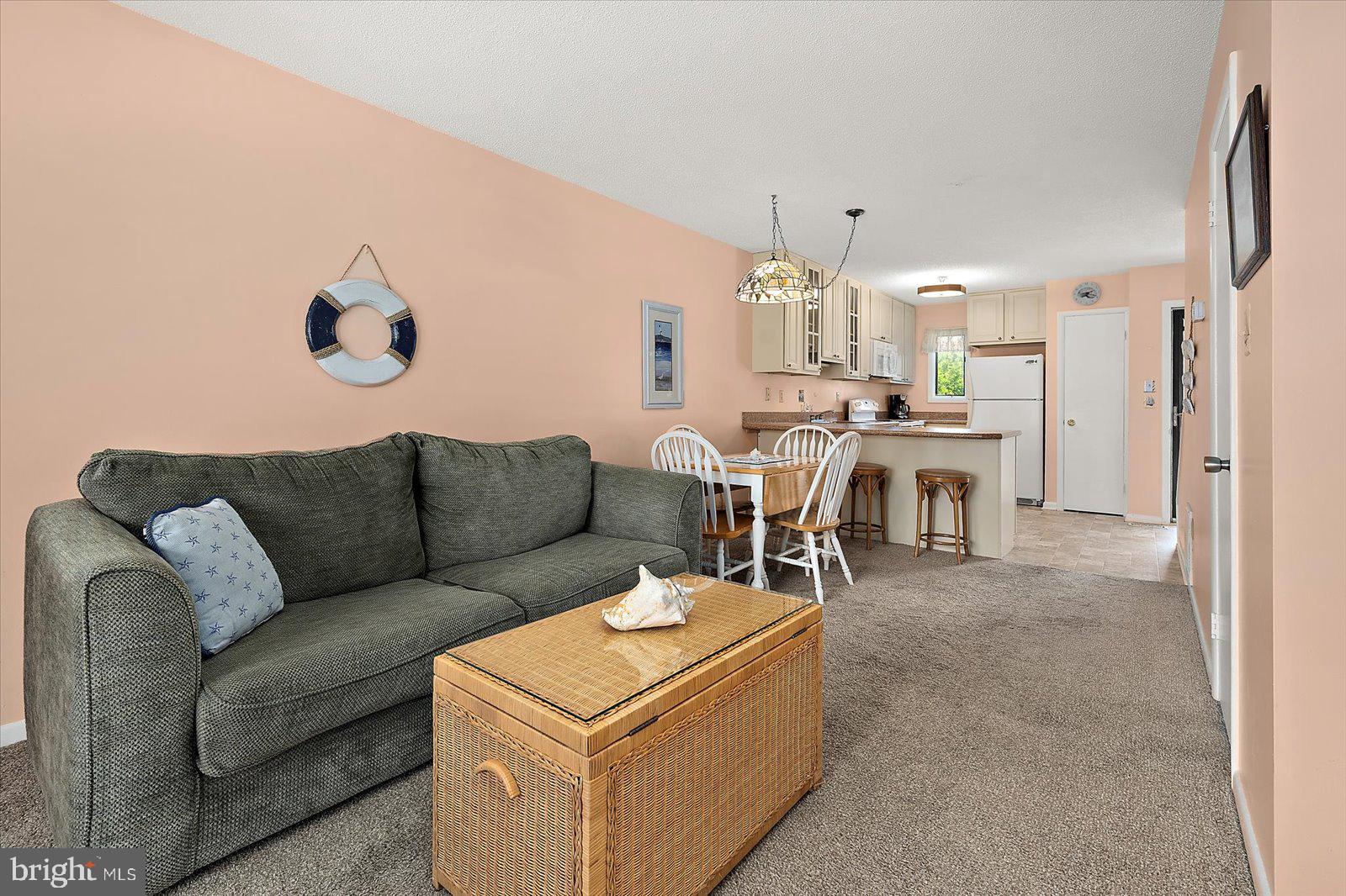 614 Osprey Road, Unit D Ocean City, MD 21842 - Photo 11 of 60 a living room with furniture a chandelier and a dining table