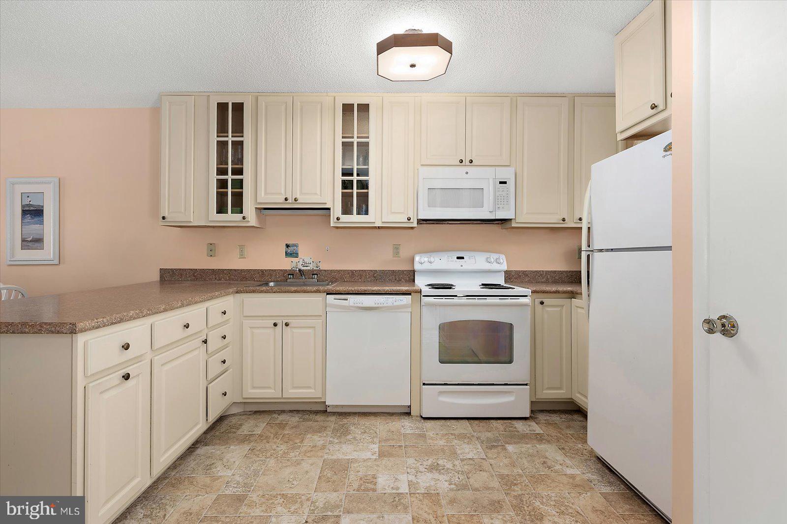 614 Osprey Road, Unit D Ocean City, MD 21842 - Photo 15 of 60 a kitchen with granite countertop white cabinets and white appliances