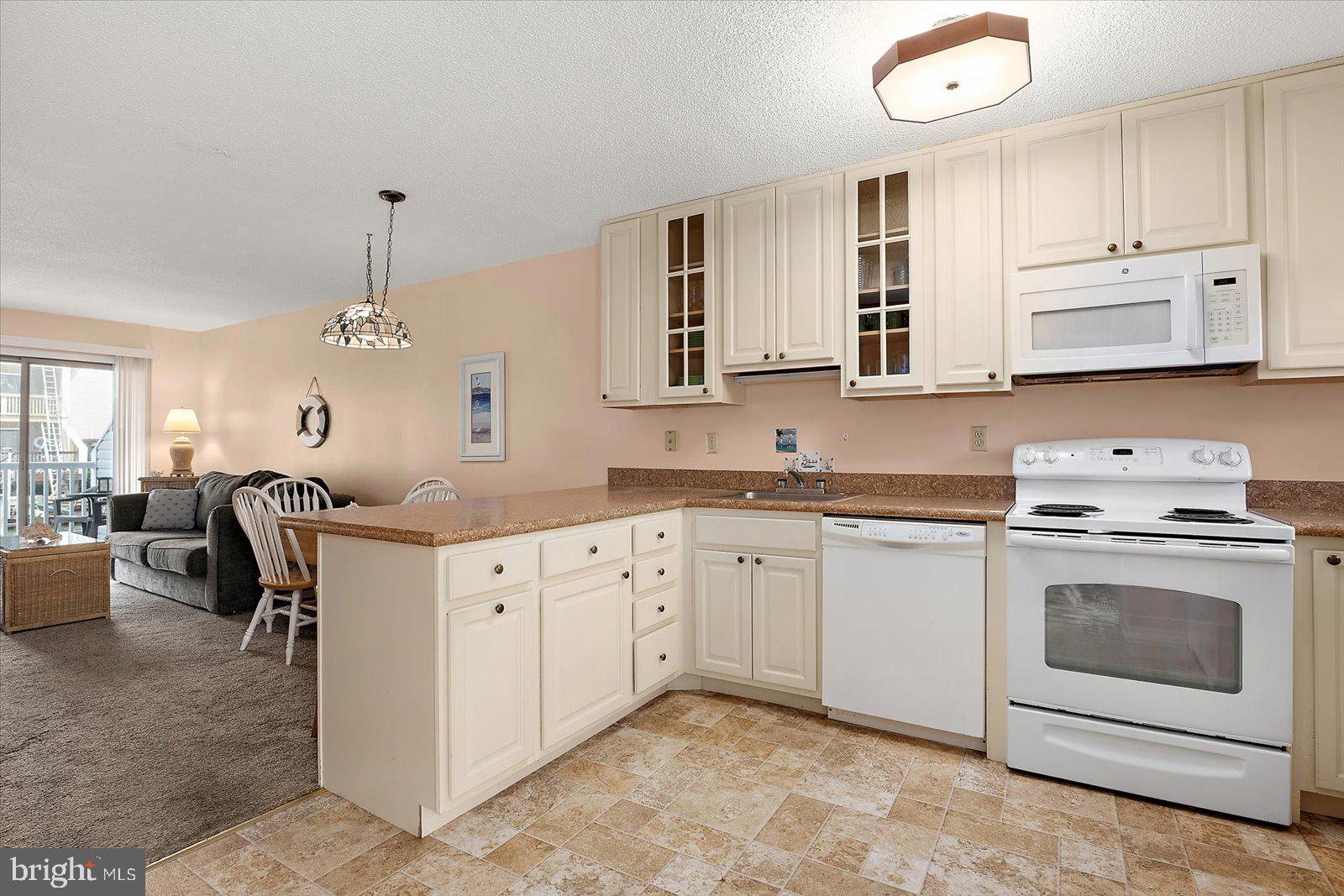 614 Osprey Road, Unit D Ocean City, MD 21842 - Photo 16 of 60 a kitchen with granite countertop cabinets stainless steel appliances and a window