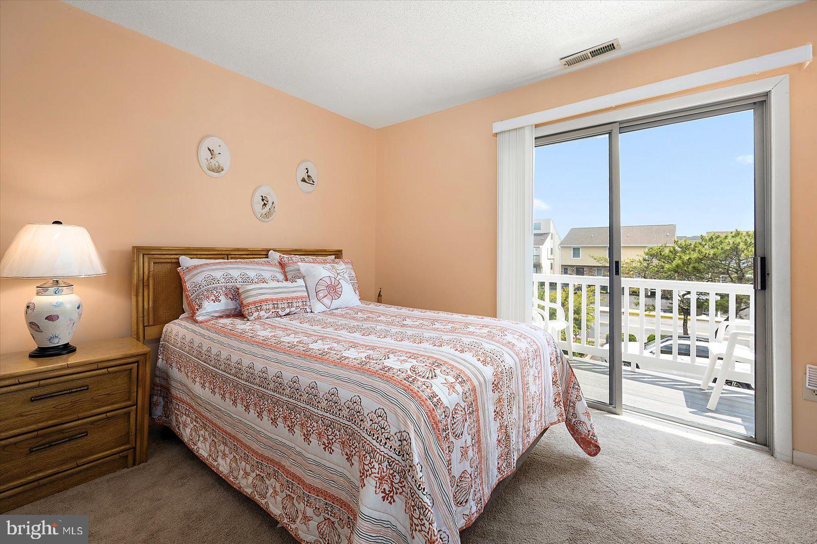 614 Osprey Road, Unit D Ocean City, MD 21842 - Photo 20 of 60 a bedroom with a bed and a night stand