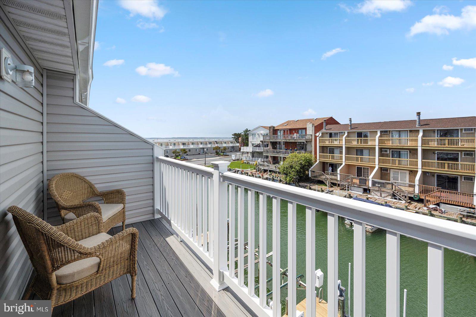614 Osprey Road, Unit D Ocean City, MD 21842 - Photo 36 of 60 a view of a balcony with two chairs and a potted plant