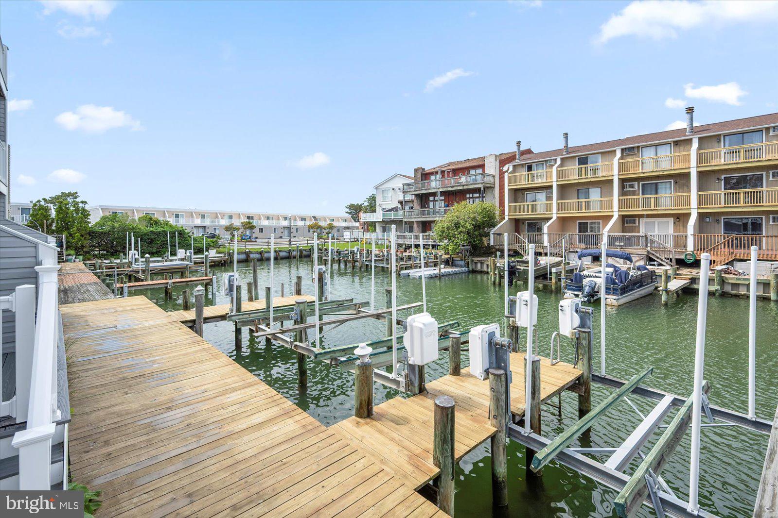 614 Osprey Road, Unit D Ocean City, MD 21842 - Photo 50 of 60 a view of a lake with boats and trees in front of it