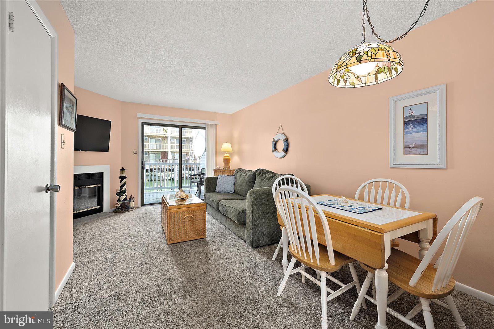 614 Osprey Road, Unit D Ocean City, MD 21842 - Photo 6 of 60 a view of a livingroom with furniture a fireplace and a chandelier