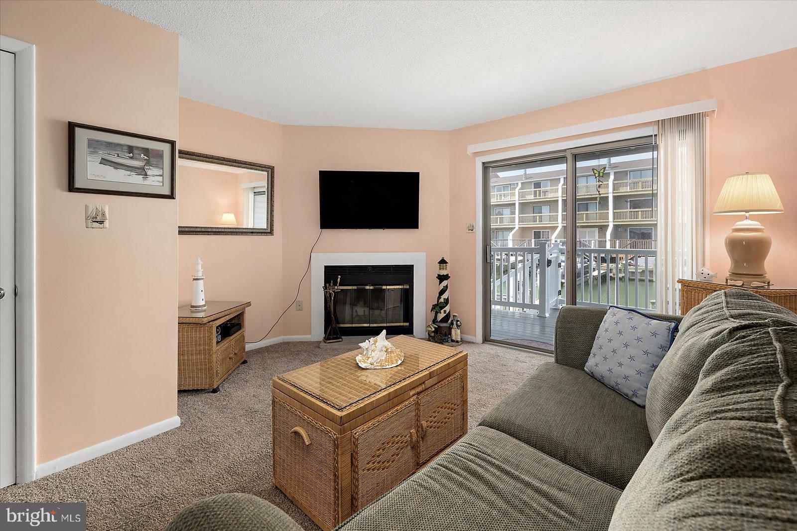 614 Osprey Road, Unit D Ocean City, MD 21842 - Photo 9 of 60 a living room with furniture a flat screen tv and a fireplace
