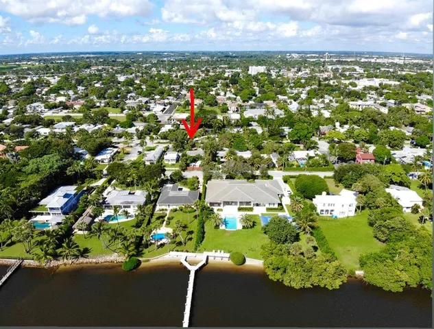 an aerial view of residential houses with outdoor space and trees