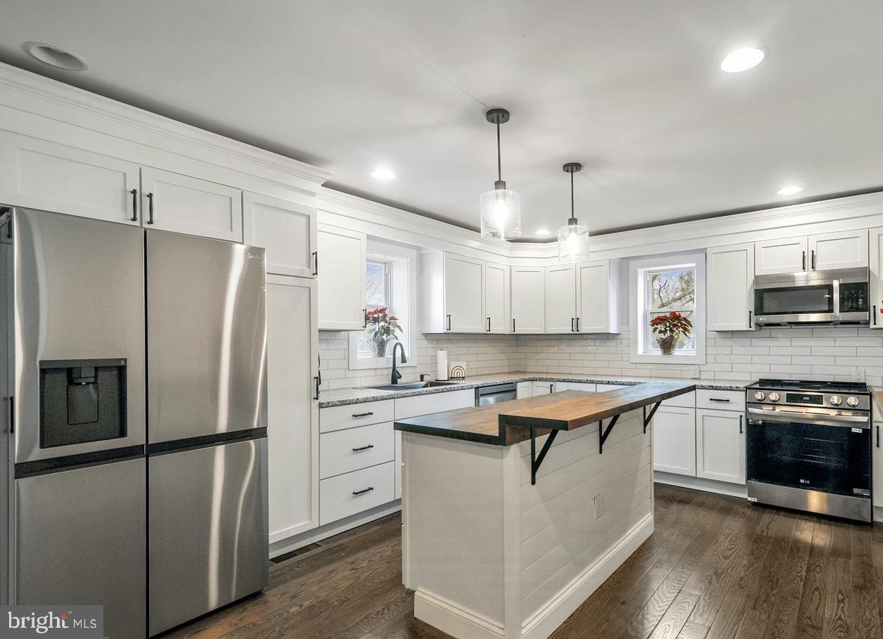 14161 Union Street Milton, DE 19968 - Photo 5 of 31 a kitchen with stainless steel appliances granite countertop a sink a stove a refrigerator and island with wooden floor