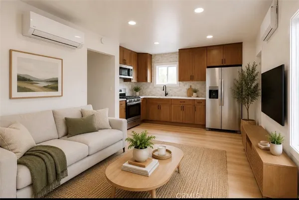a living room with furniture kitchen view and a flat screen tv