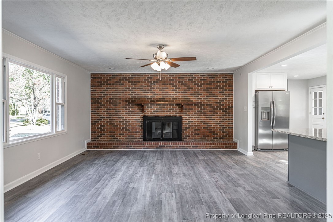 255 Foxcroft Road Whispering Pines, NC 28327 - Photo 5 of 31 a living room with a fireplace and wooden floor
