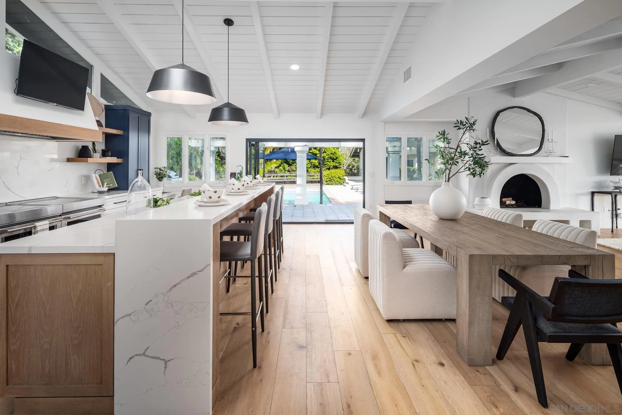 16610 Los Morros Rancho Santa Fe, CA 92067 - Photo 11 of 50 a kitchen with stainless steel appliances kitchen island granite countertop a stove a sink a dining table and chairs with wooden floor
