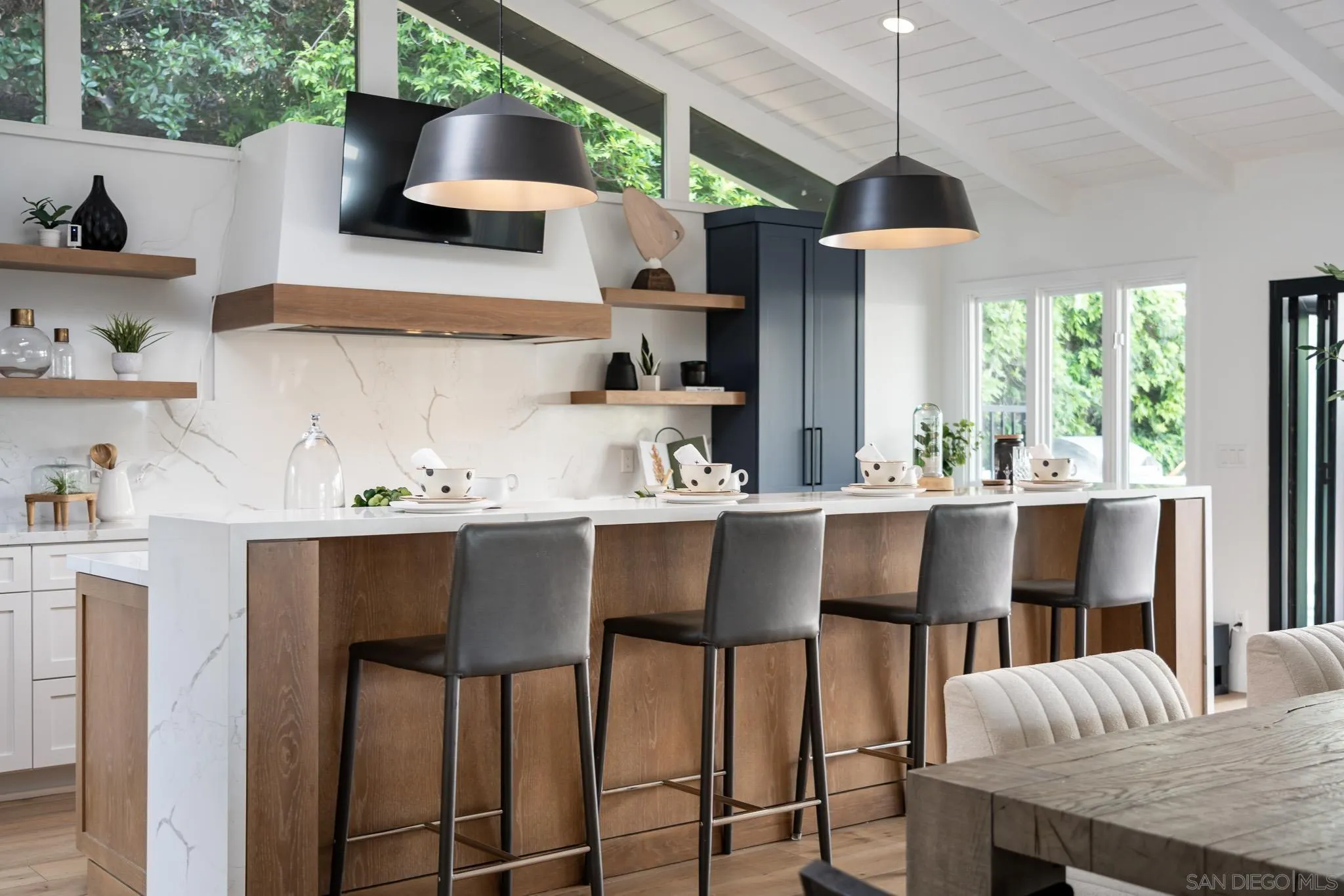 16610 Los Morros Rancho Santa Fe, CA 92067 - Photo 10 of 50 a kitchen with stainless steel appliances granite countertop a table chairs in it and wooden floors