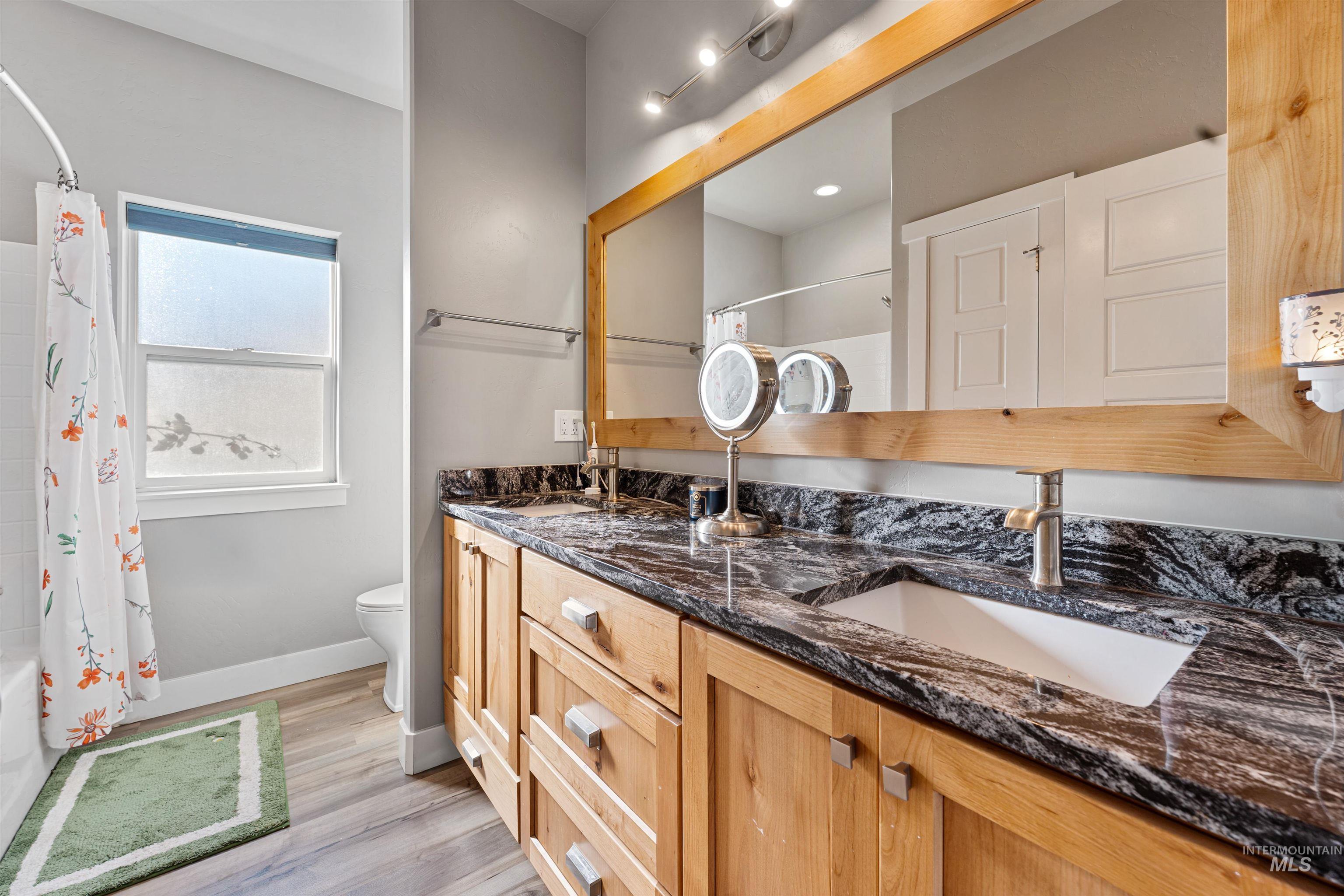 1005 Kenbrook Loop Twin Falls, ID 83301 - Photo 13 of 47 Bathroom featuring double vanity, shower / tub combo with curtain, and light wood finished floors