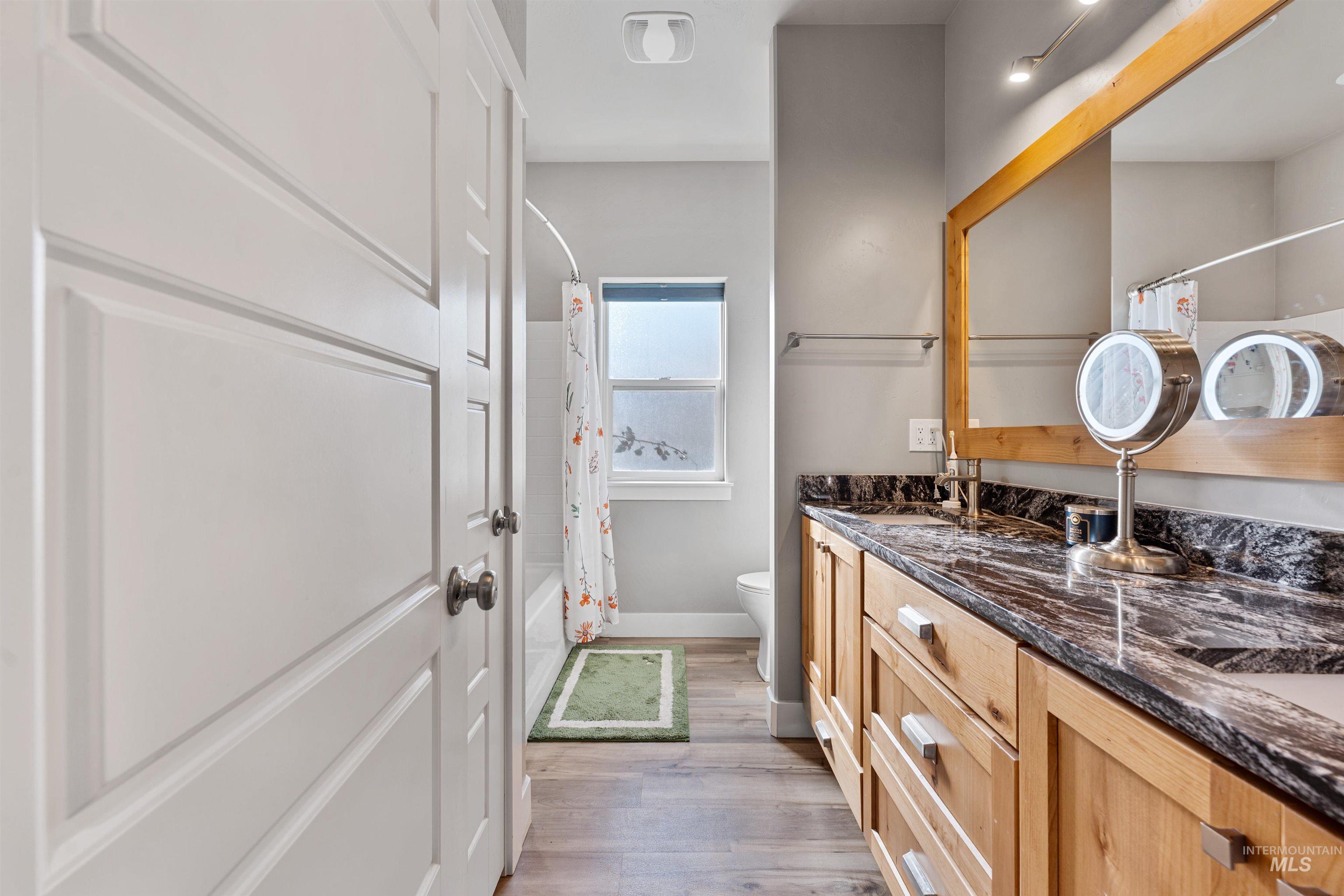 1005 Kenbrook Loop Twin Falls, ID 83301 - Photo 14 of 47 Full bathroom featuring shower / tub combo with curtain, double vanity, and light wood-style flooring