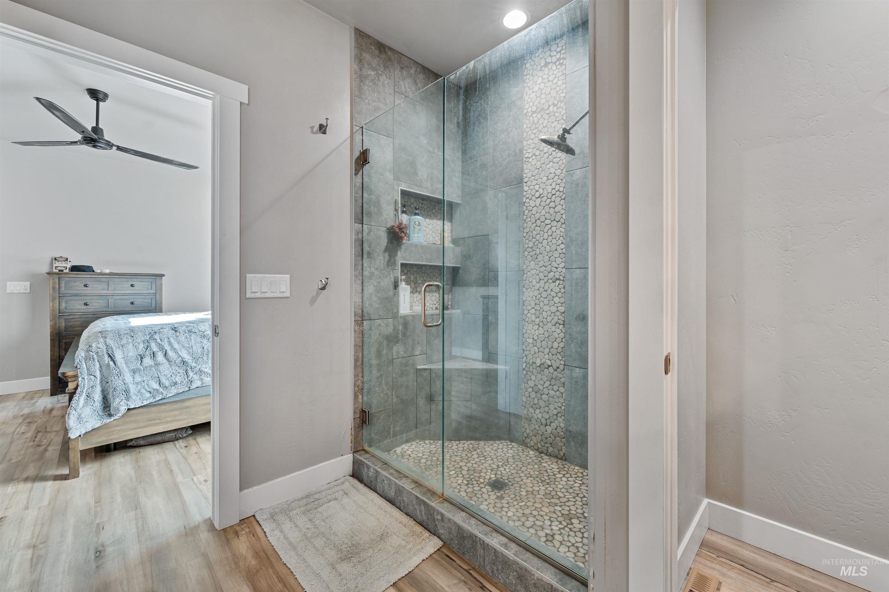 1005 Kenbrook Loop Twin Falls, ID 83301 - Photo 19 of 47 Bathroom with a stall shower, wood finished floors, ceiling fan, and connected bathroom