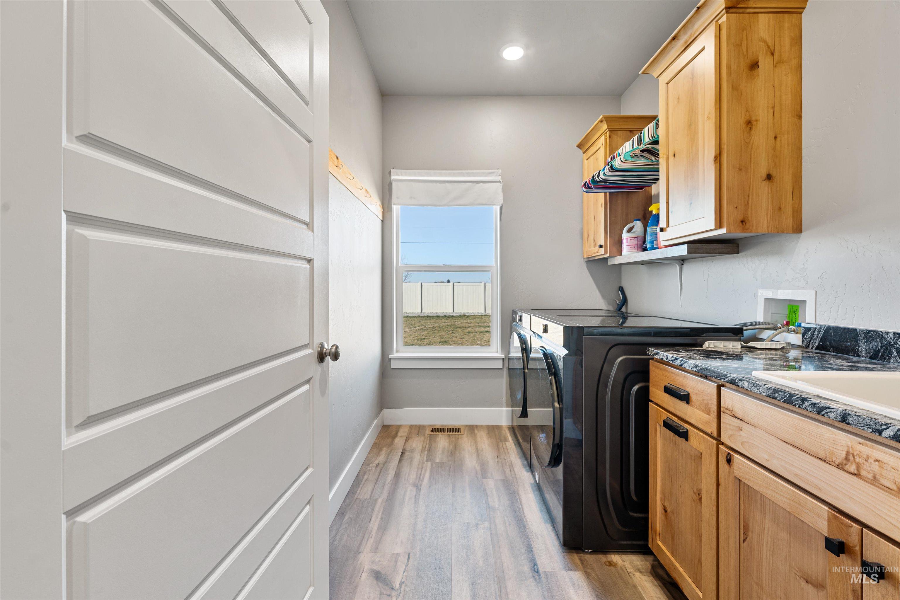 1005 Kenbrook Loop Twin Falls, ID 83301 - Photo 27 of 47 Laundry area featuring light wood-style flooring, separate washer and dryer, cabinet space, and recessed lighting