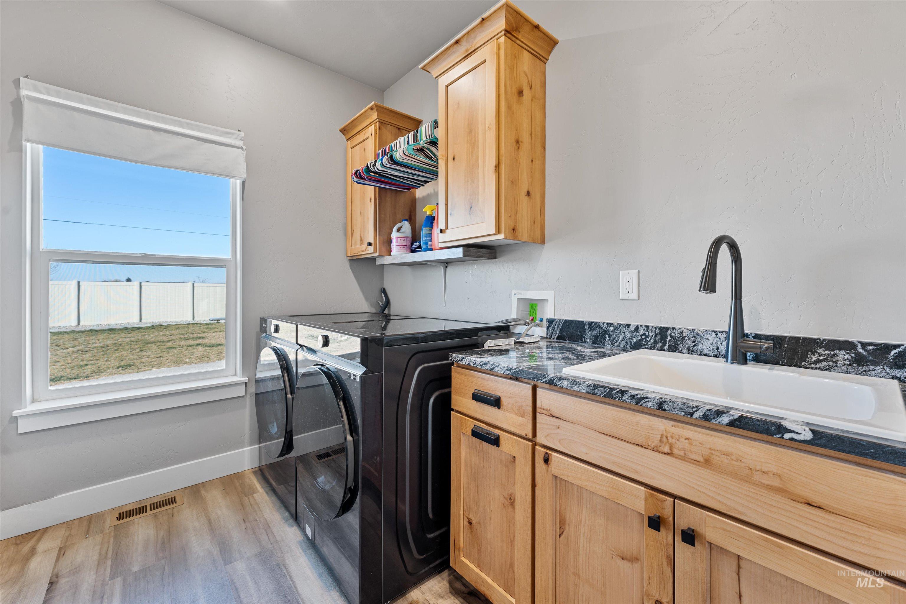 1005 Kenbrook Loop Twin Falls, ID 83301 - Photo 28 of 47 Laundry area with cabinet space, washer and dryer, and light wood finished floors