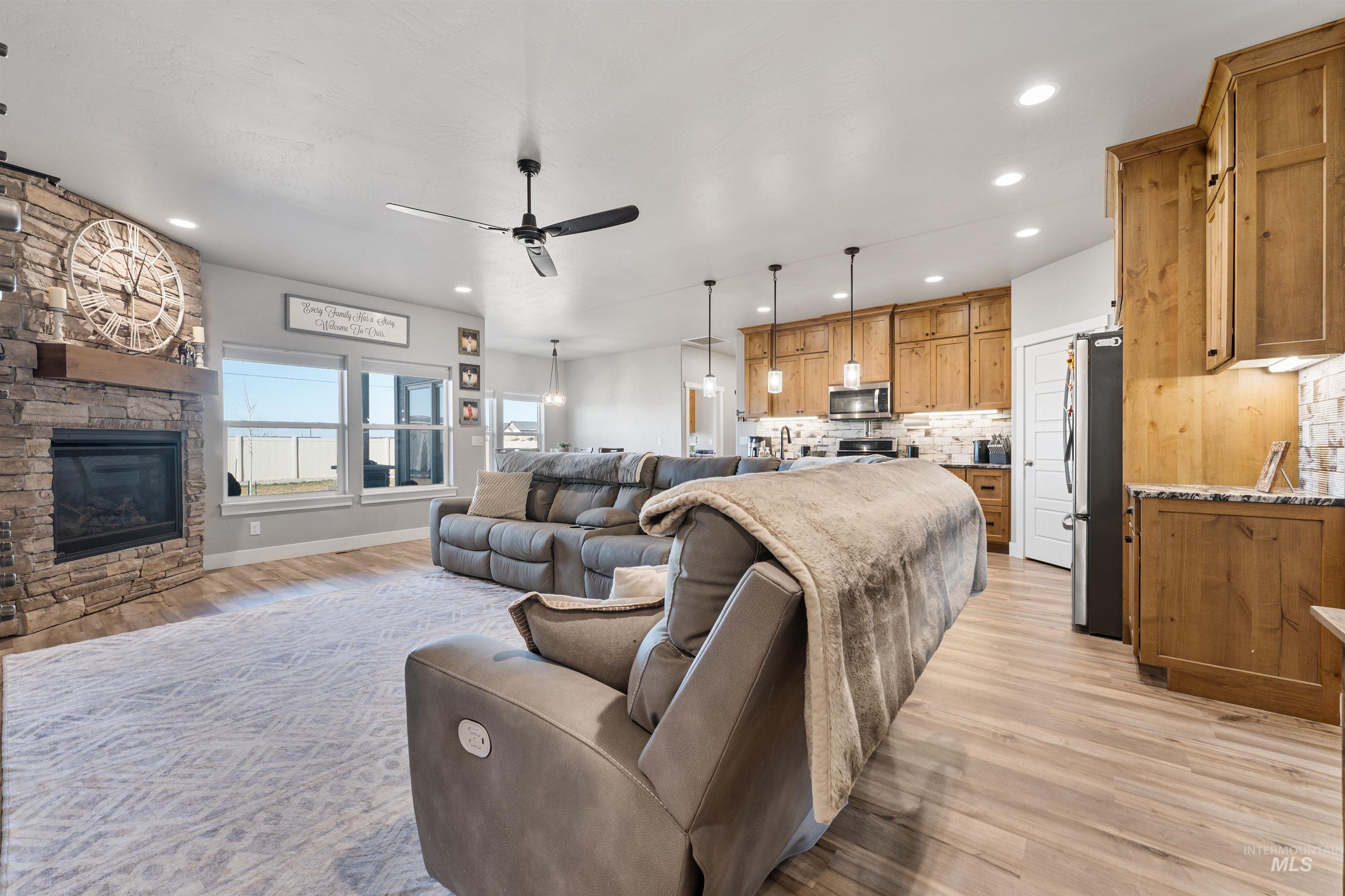 1005 Kenbrook Loop Twin Falls, ID 83301 - Photo 4 of 47 Living room featuring light wood-style flooring, a ceiling fan, a fireplace, and recessed lighting