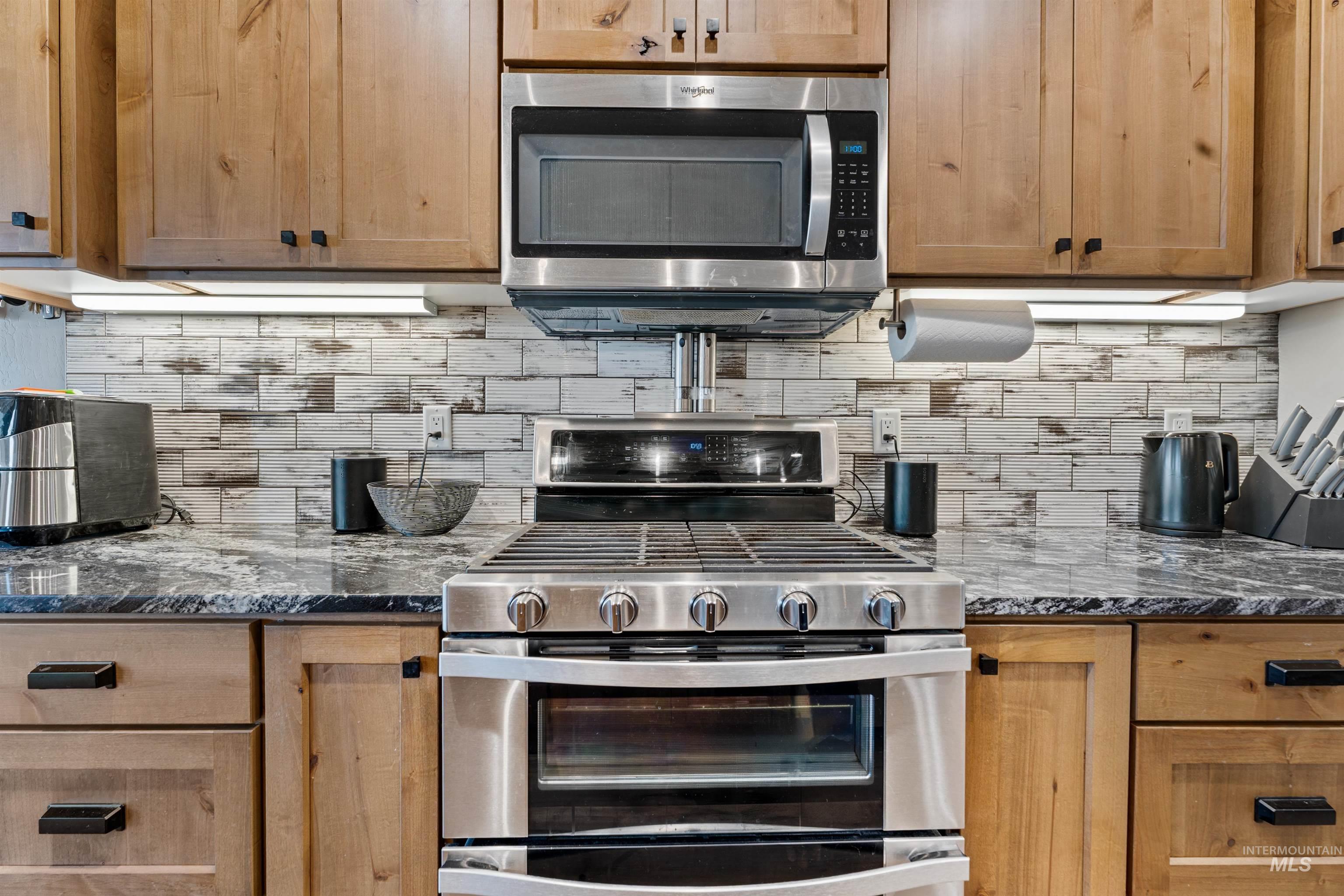 1005 Kenbrook Loop Twin Falls, ID 83301 - Photo 8 of 47 Kitchen with stainless steel appliances, dark stone countertops, and tasteful backsplash
