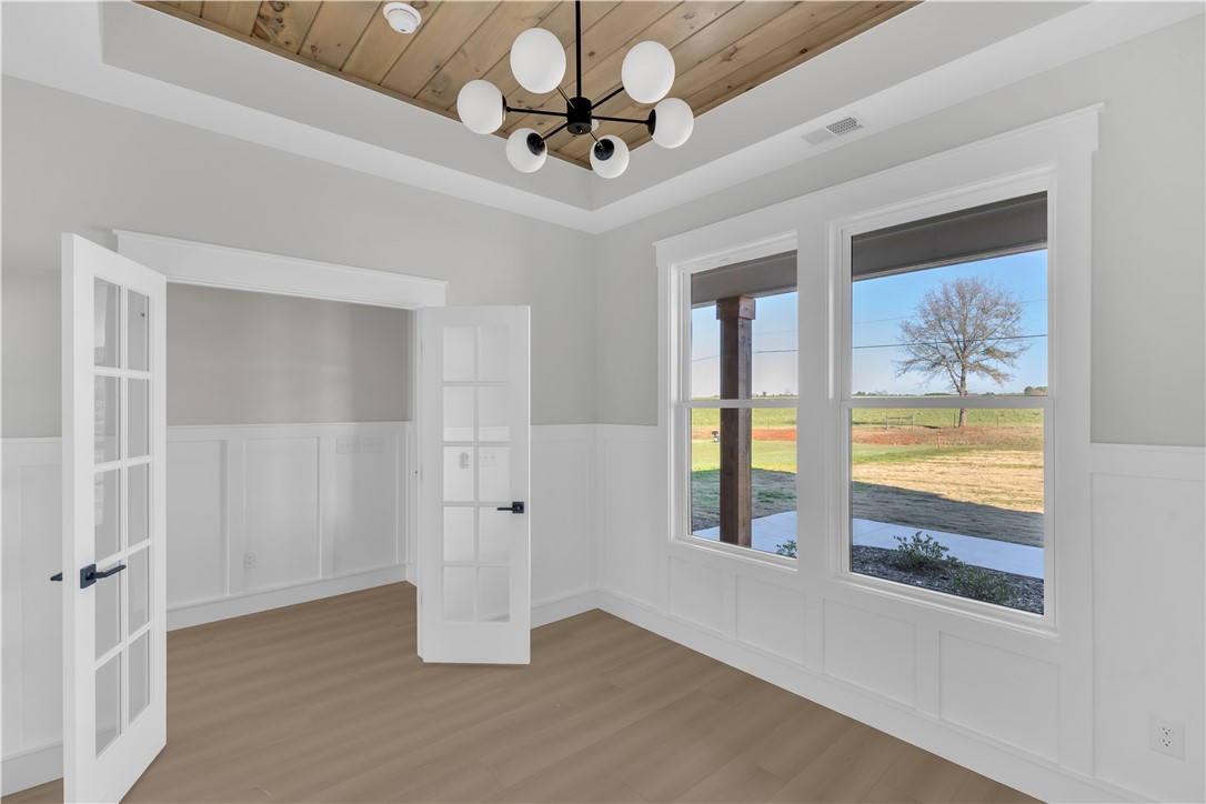516 Lakeside Drive Anderson, SC 29621 - Photo 8 of 32 A refined interior space features rich hardwood flooring and large windows, offering expansive pastoral views.