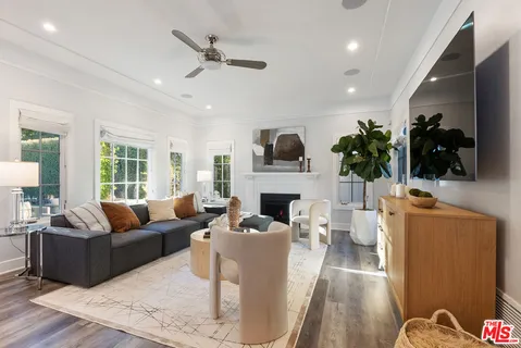 a living room with furniture kitchen view and a large window