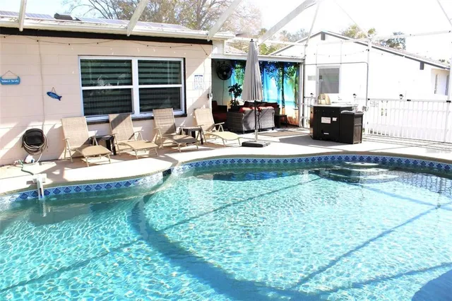a view of a house with swimming pool and sitting space