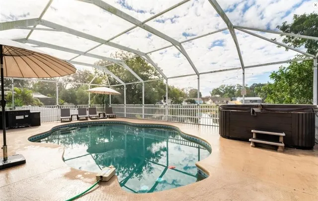 a view of a swimming pool with a patio and a tub