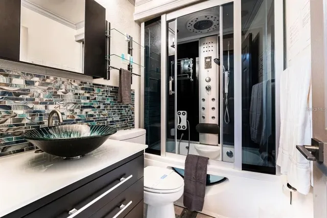 a bathroom with a sink a toilet and a large mirror