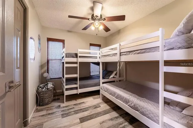 a bedroom with a bed and a ceiling fan