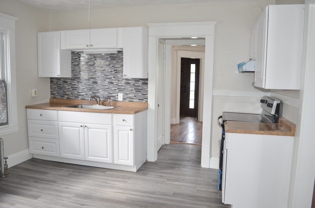 25 Eton Street Springfield, MA 01108 - Photo 3 of 31 a kitchen with stainless steel appliances cabinets and wooden floor